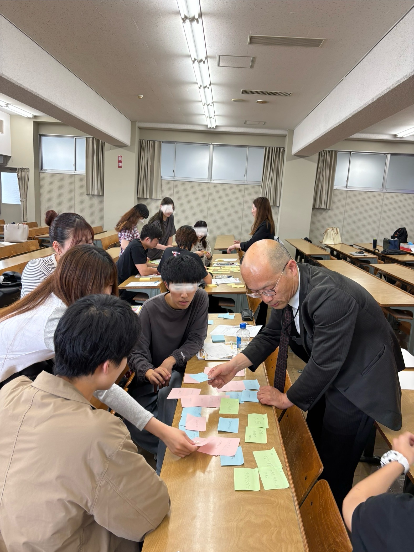 意見をまとめる学生と(株)籠谷の総務部長