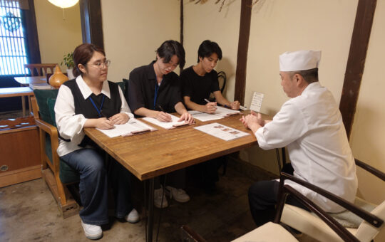 古民家レストランの店主に聞き取り調査をするC地区班