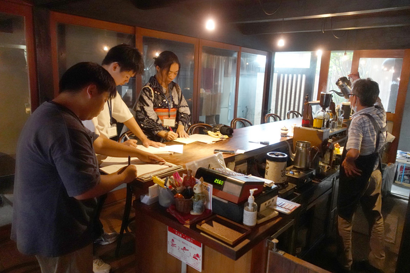 古民家を活かした老舗喫茶店の店主に聞き取り調査をするE地区班