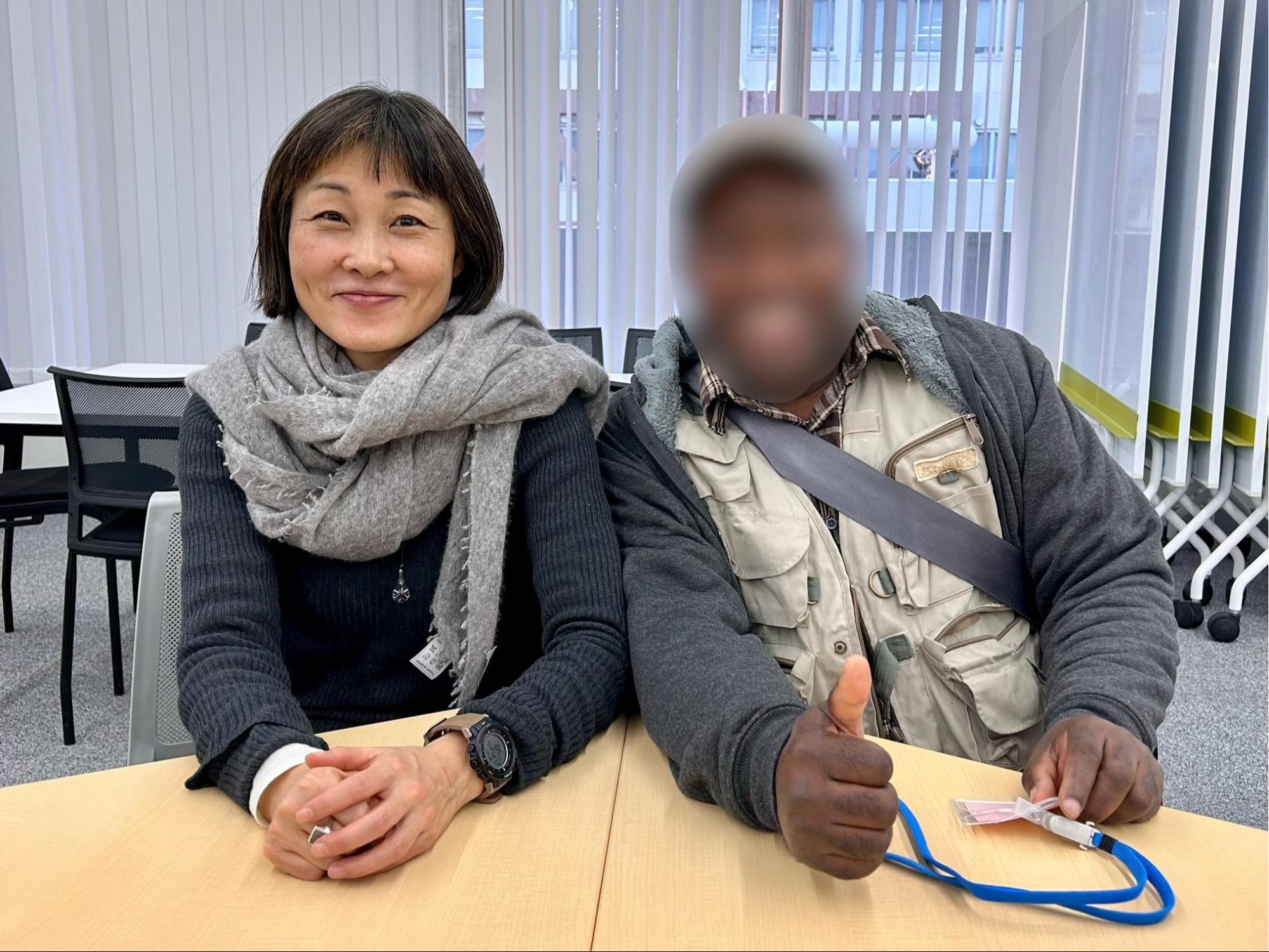 笑顔で寄り添う翻訳家のふしみみさをさんと難民申請者のBさん
